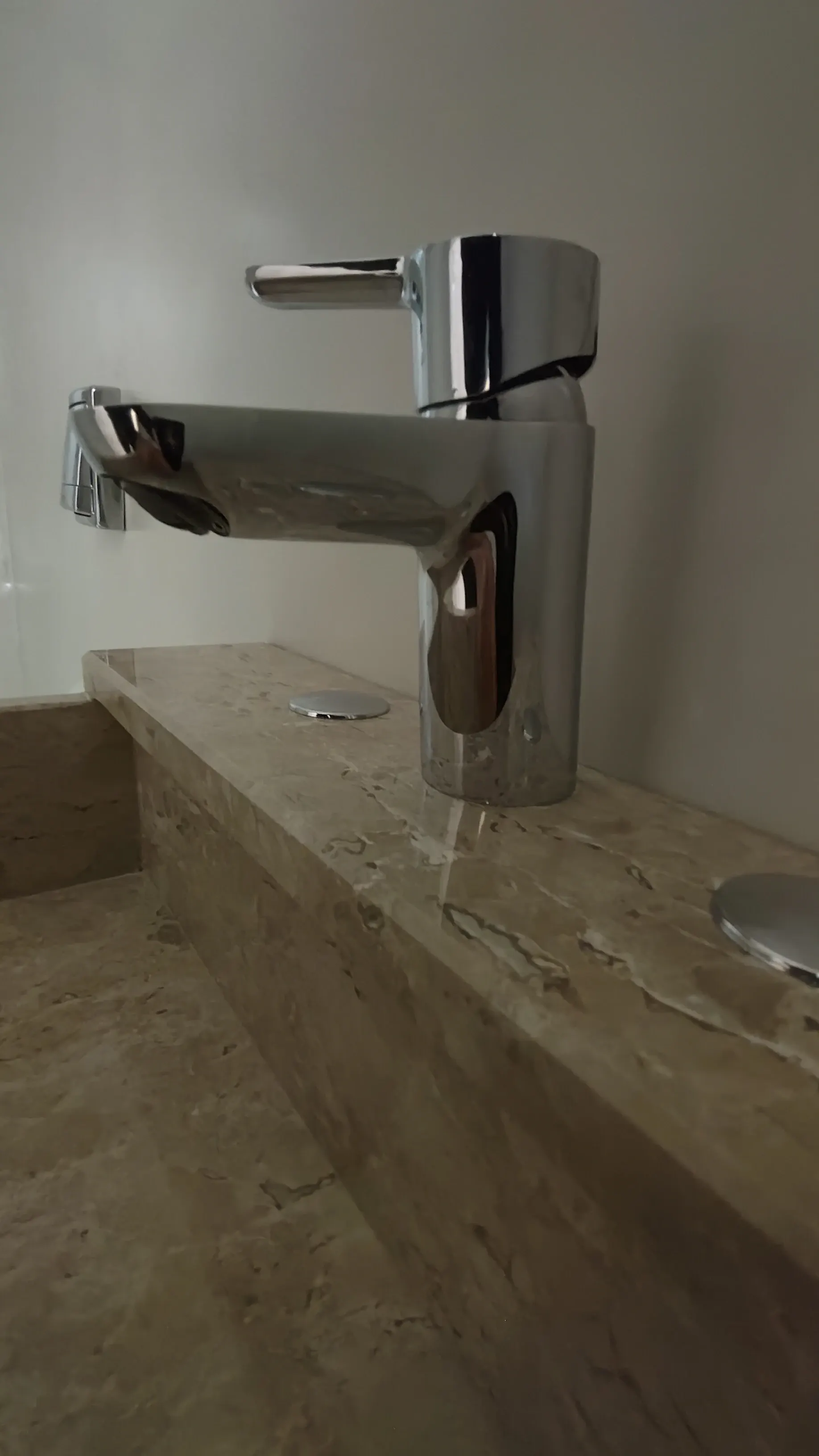 Grifería monocomando sobre bacha de baño en mármol